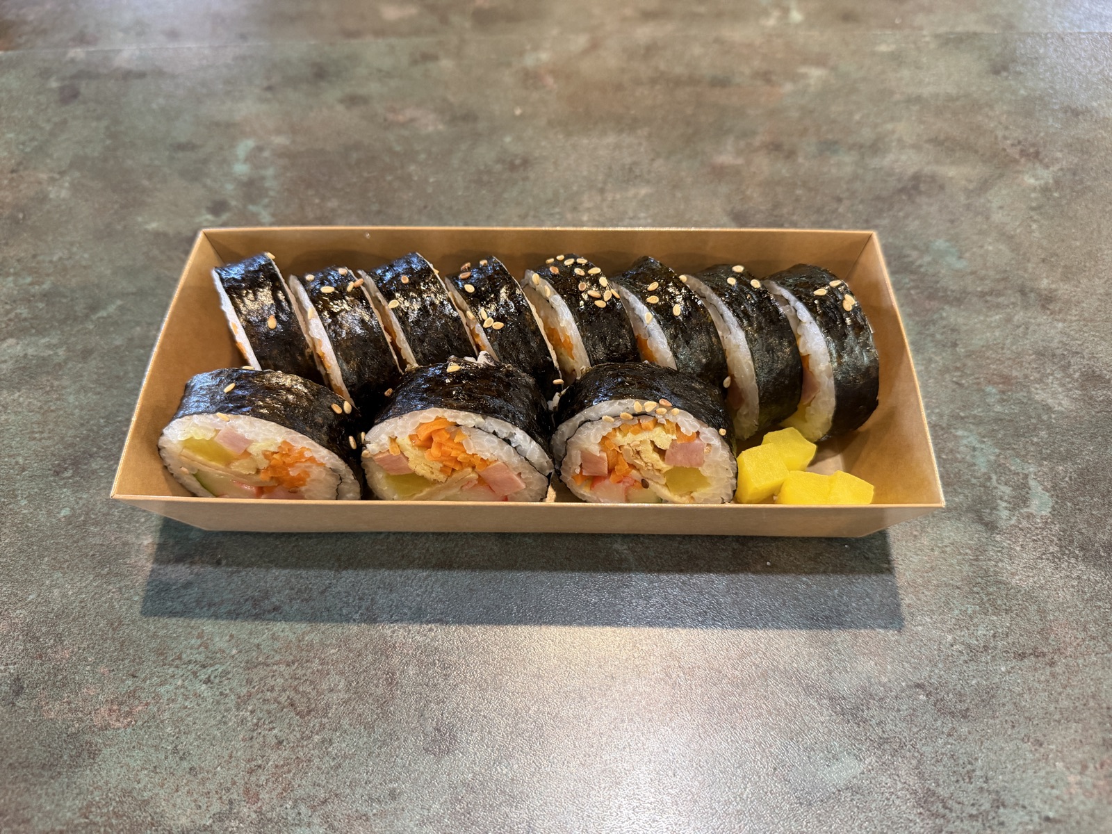 Classic kimbap rolls in a takeout box